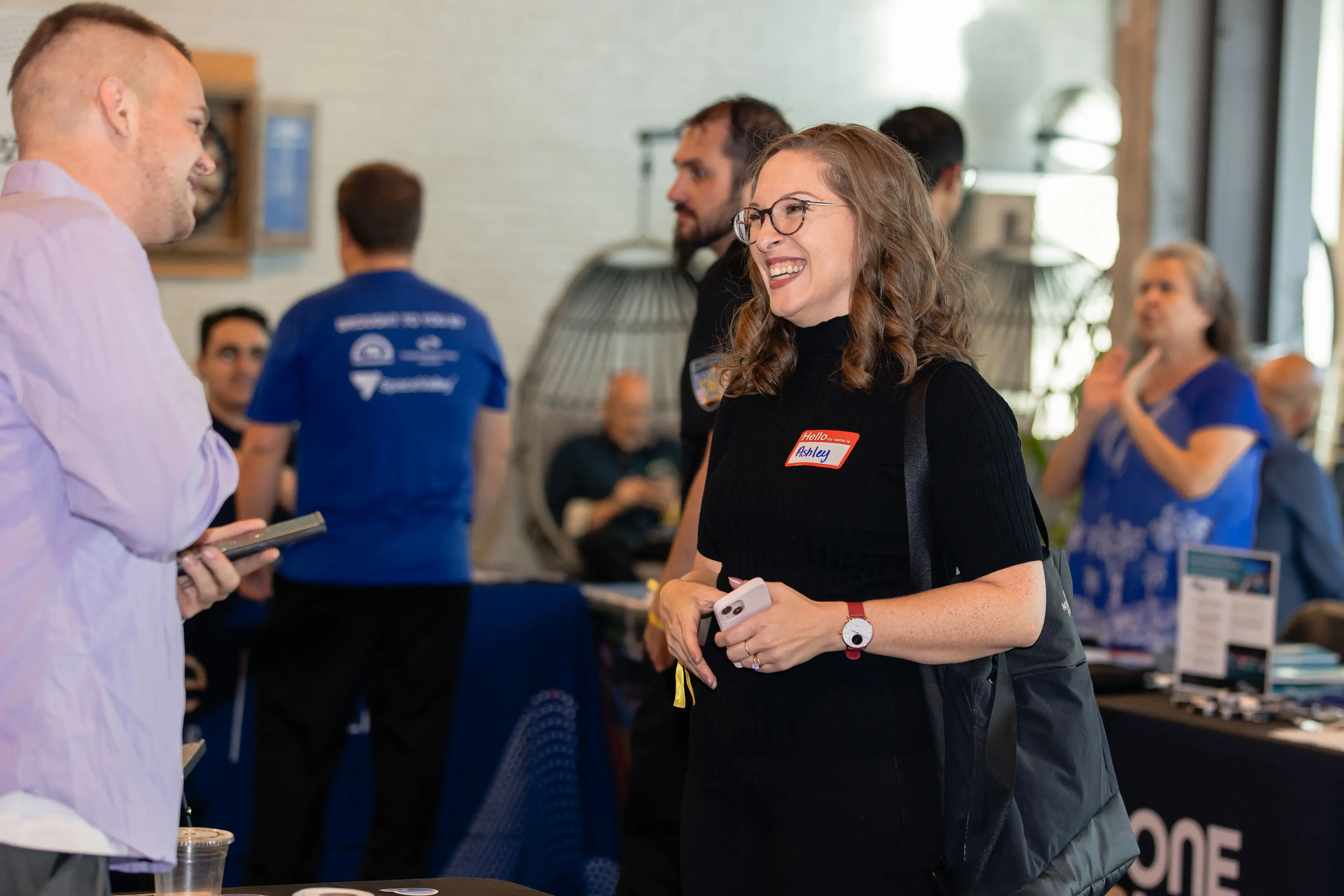 Attendee with name tag networking and having conversation at TechFest 2024